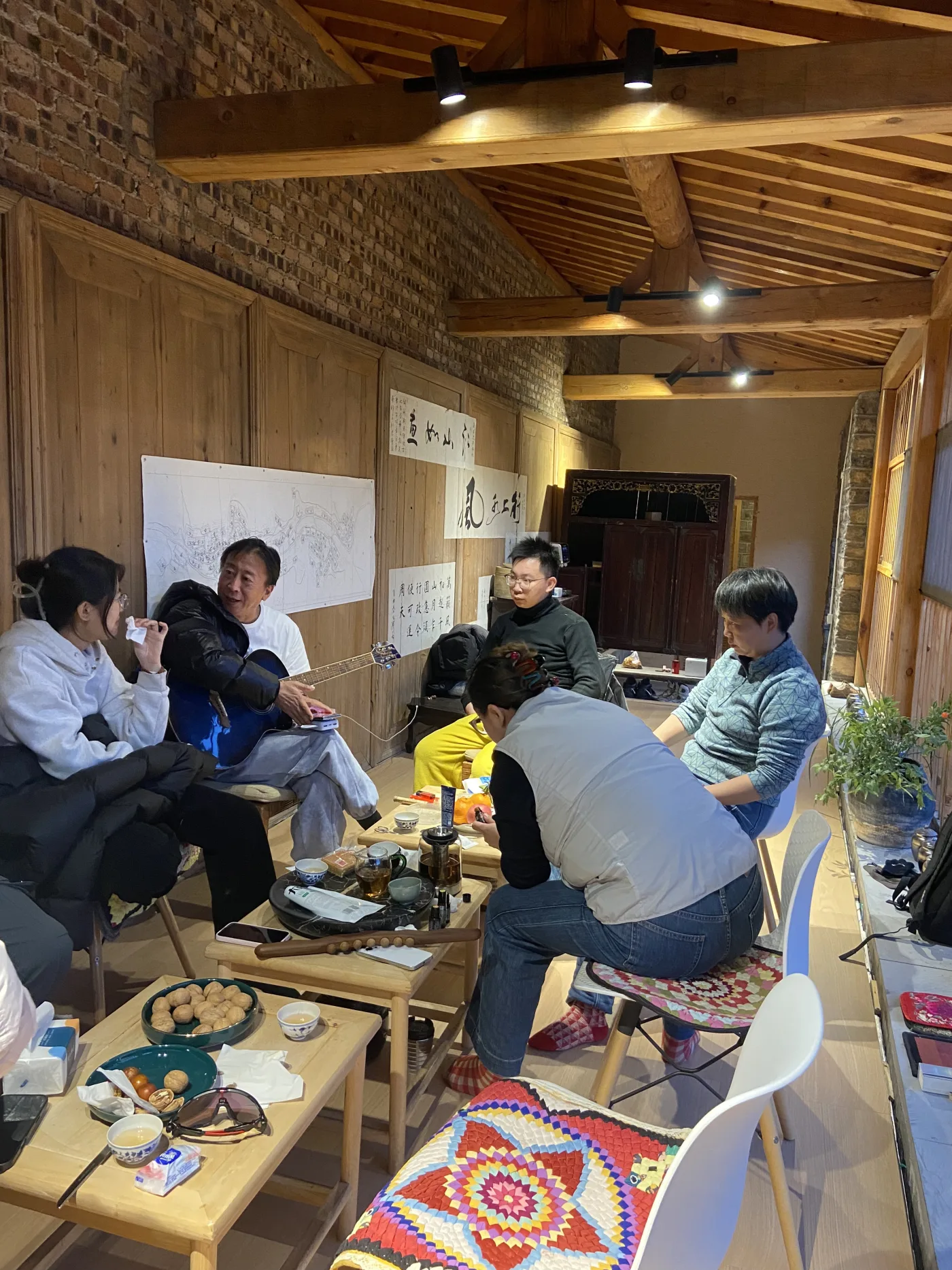 朋友们在乡村屋内喝茶、聊天与弹琴